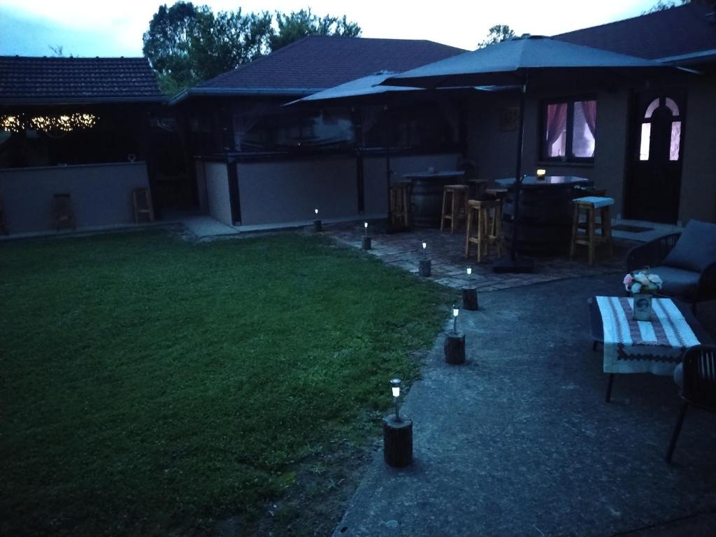 a backyard with a table and some lights on the grass at Kuća za odmor San in Lonja