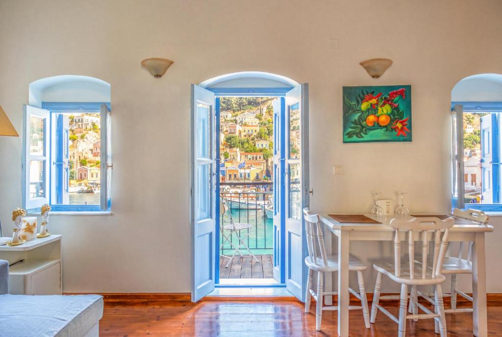 a dining room with a table and two windows at Nikolakis, Seafront- Harbor view in Symi