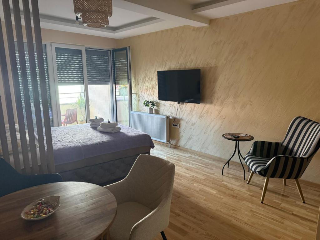 a hotel room with a bed and a table and chairs at PRESTIGE studio Krusevac in Kruševac
