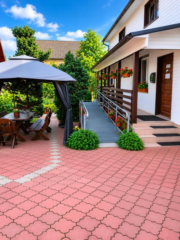 a patio with a table and an umbrella next to a building at Pokoje gościnne u Antka in Krynki