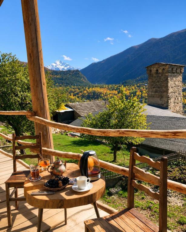 a table and chairs on a deck with a view at Guest House Keti Margiani Mestia in Mestia
