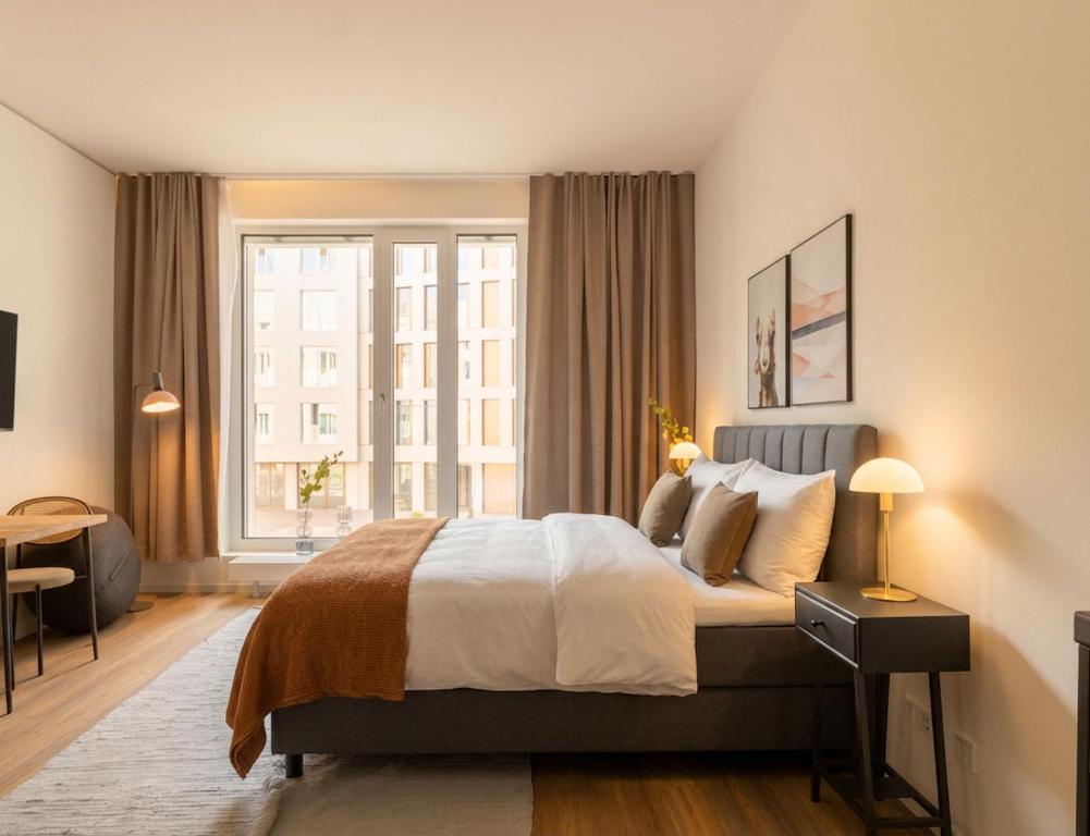 a bedroom with a bed and a large window at Limehome Berlin Müllerstraße - Digital Access in Berlin