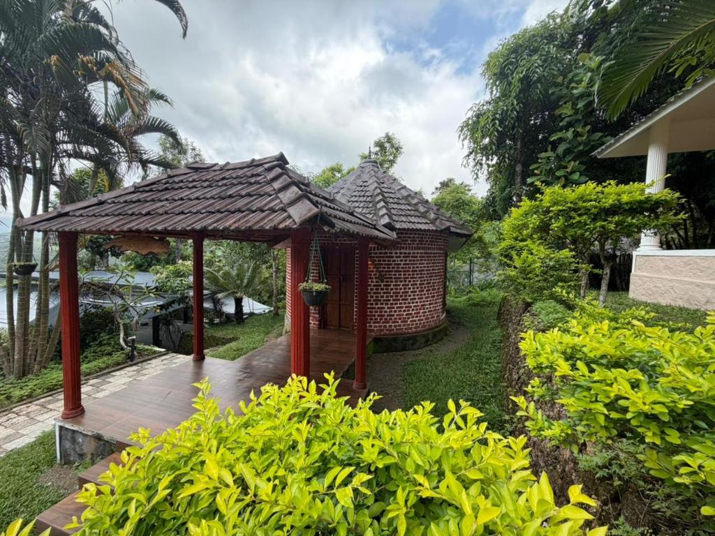 a small wooden gazebo with a roof at Sumeru valley vagamon in Idukki