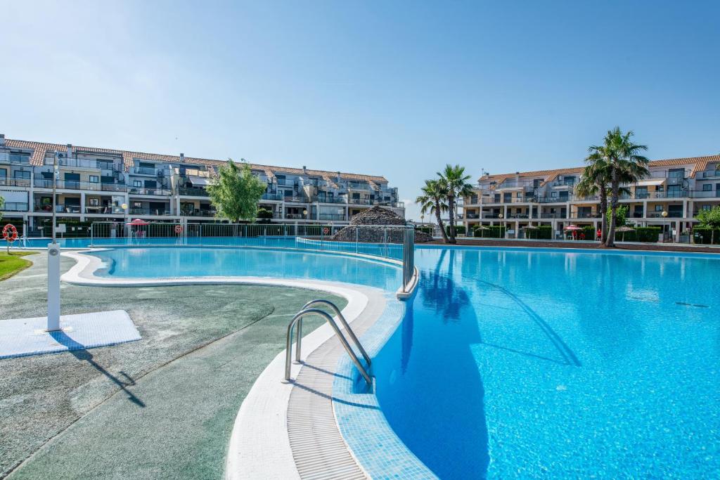 a large swimming pool in front of a apartment complex at Apartment In Golf Mar Resort in San Jorge
