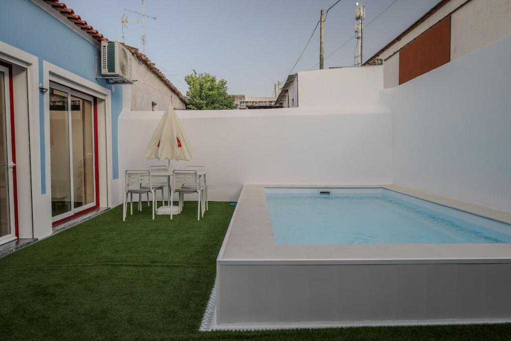 a backyard with a swimming pool and a table and chairs at Casa dos Manos in Barbacena