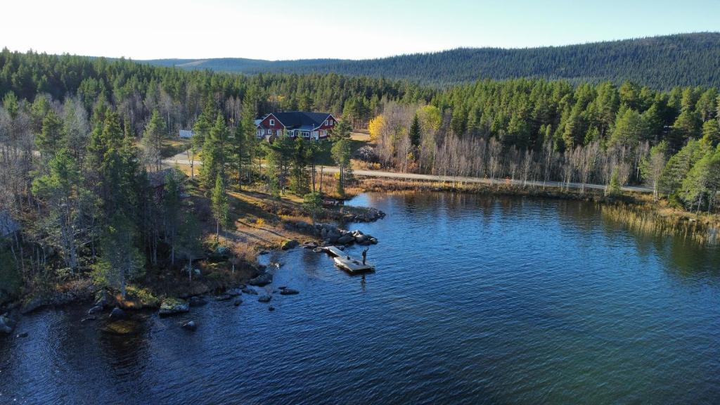 an aerial view of a house on the shore of a lake at Villa Björklund - Lakeview Apartment in Swedish Lapland in Arjeplog