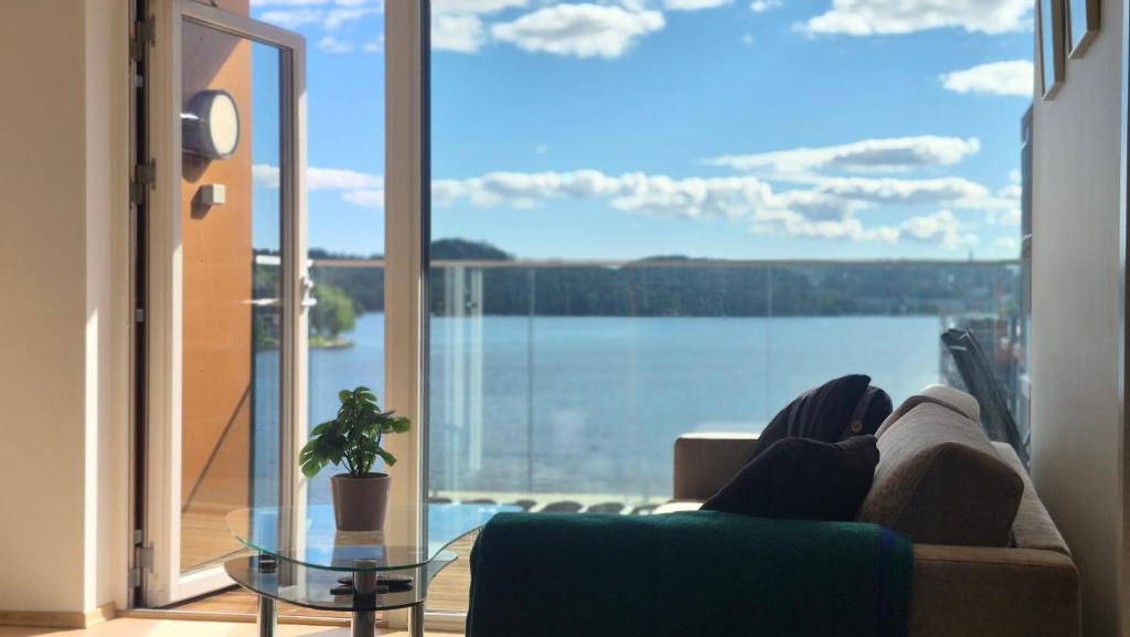 a living room with a couch and a view of the water at Seabreeze Suite in Arendal
