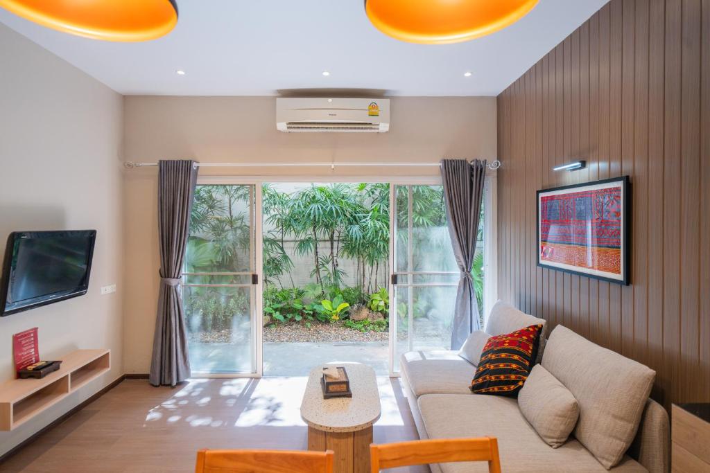 A second angle shows the living room facing a planted garden through full-height doors.