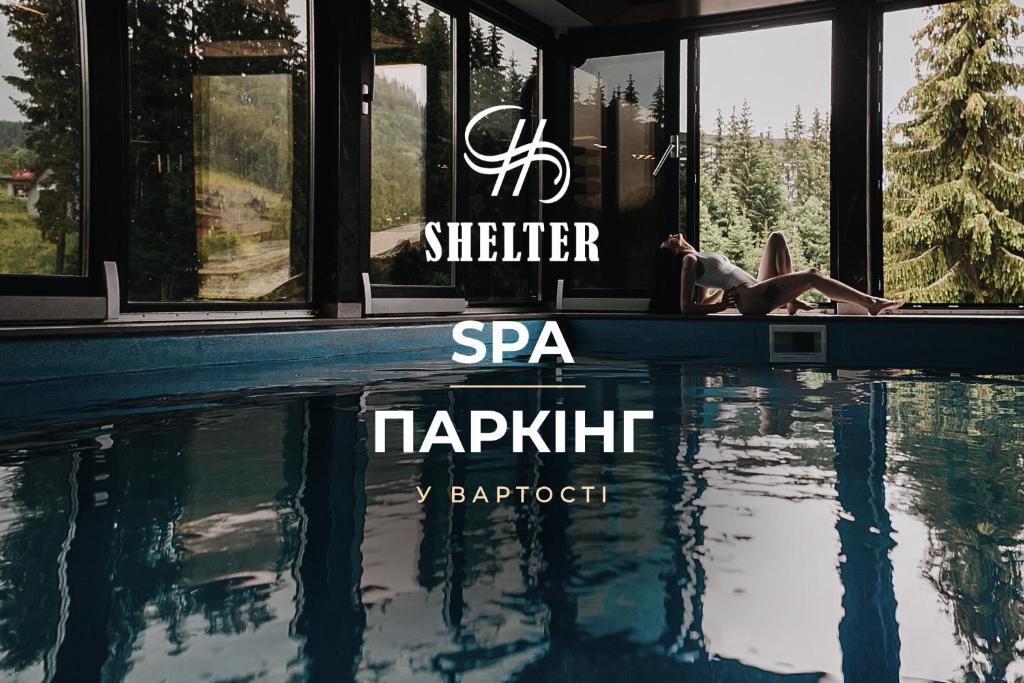 a person is standing next to a swimming pool at Shelter Apart Hotel in Bukovel