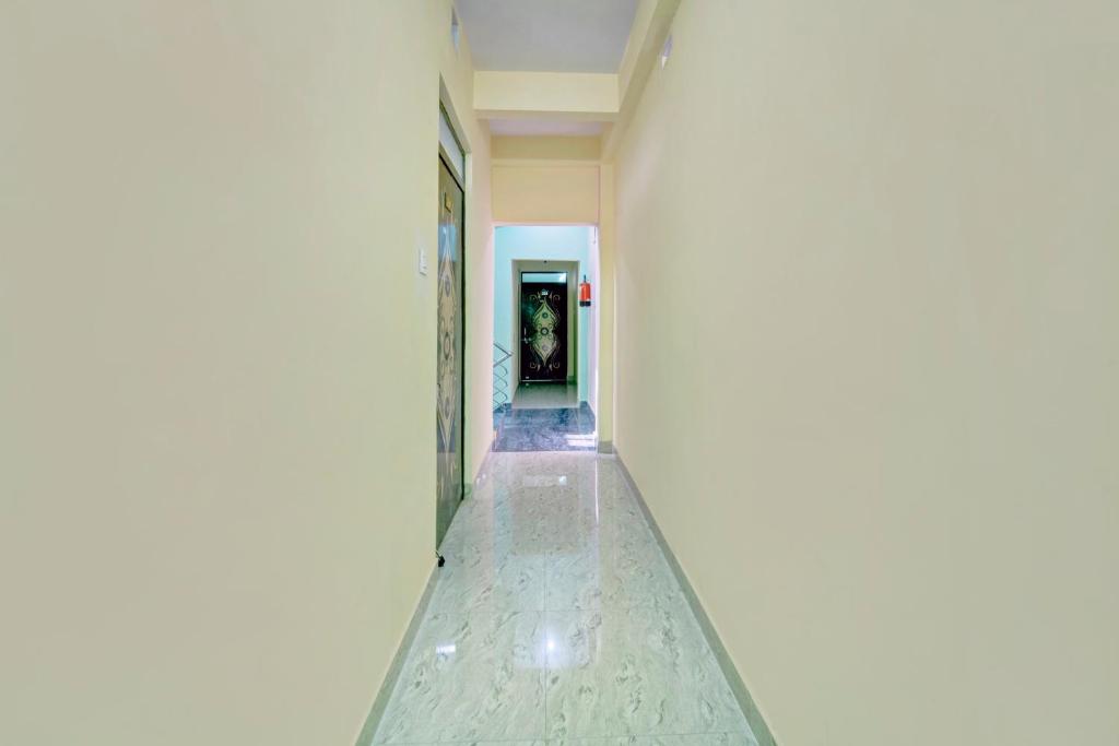 a hallway with a white wall and a white floor at Hotel O City View in Dānāpur