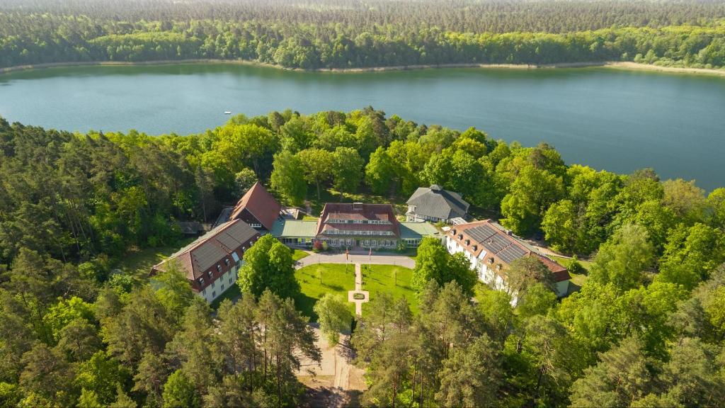 an aerial view of a house on the shore of a lake at Hotel Döllnsee-Schorfheide in Templin