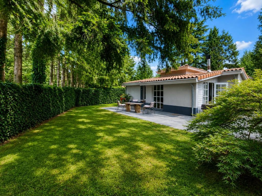 a small white house with a fence and a yard at Villa Mar veluwe in Ermelo