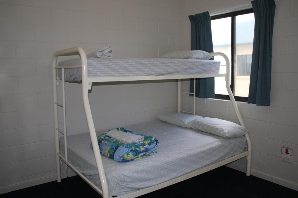 two bunk beds in a room with a window at Ningaloo Coral Bay Backpackers in Coral Bay