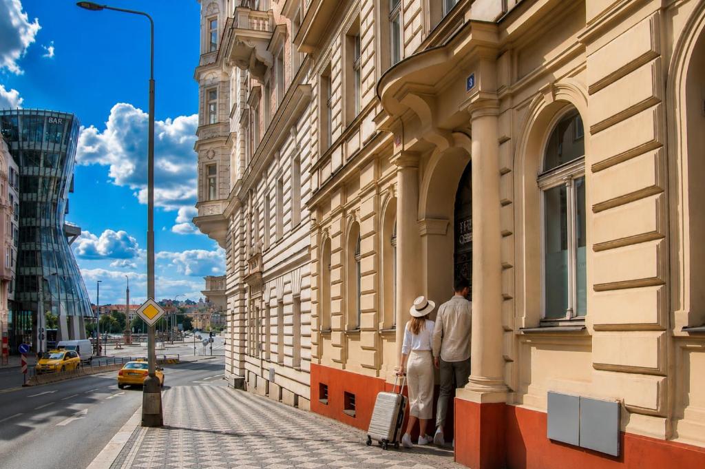 two people standing outside of a building on a street at Riverside Palace Apartments in Prague