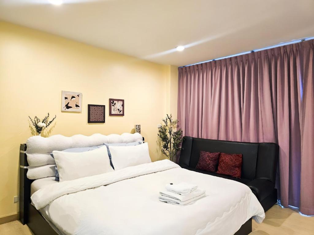 a bedroom with a large white bed and a window at The Beach Bangsaen Condo 327/30 in Ban Bang Saen (1)
