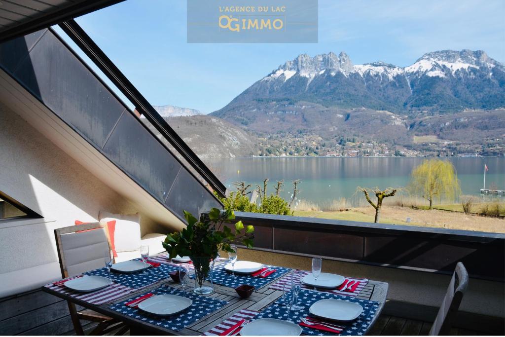 a balcony with a table and a view of a mountain at Lac paradisiaque in Duingt