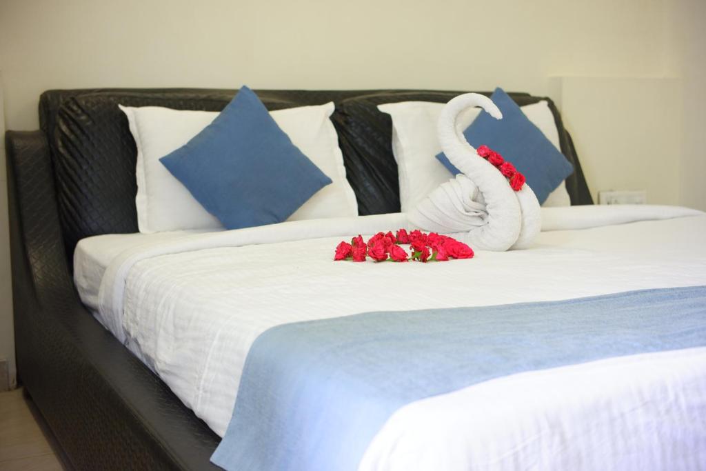 a bed with red flowers on top of it at Hotel Sai Miracle in Shirdi