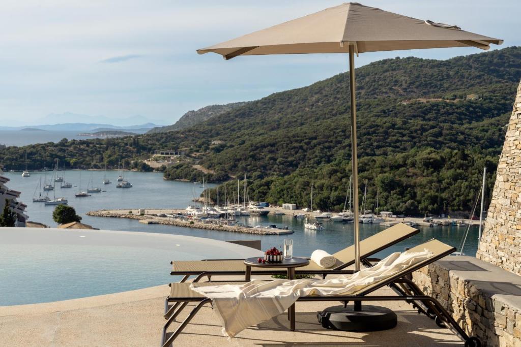 a patio with a table and an umbrella and chairs at KHAI Syvota in Syvota