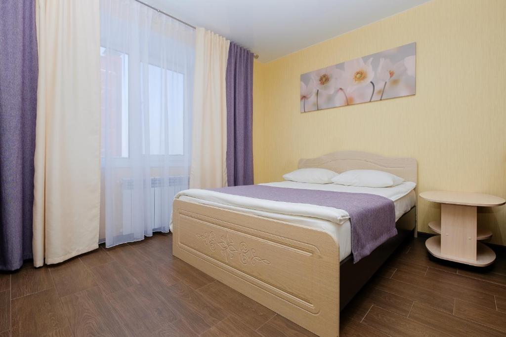 トムスクにあるApart Petrovskie at Savinykh 4Aのベッドルーム(ベッド1台、テーブル付)