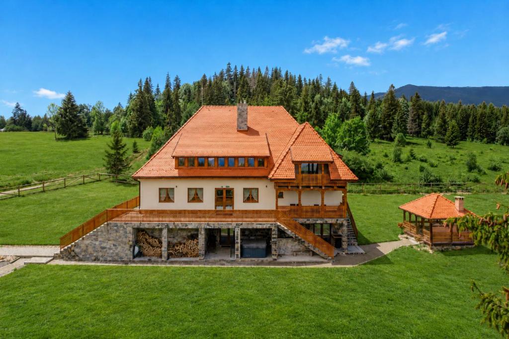 a house with an orange roof on a green field at ROGOChalet in Rogojel