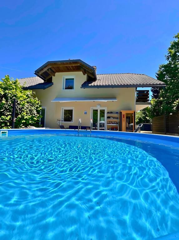 a villa with a swimming pool in front of a house at Quiet Forest Retreat with Pool in Borovnica