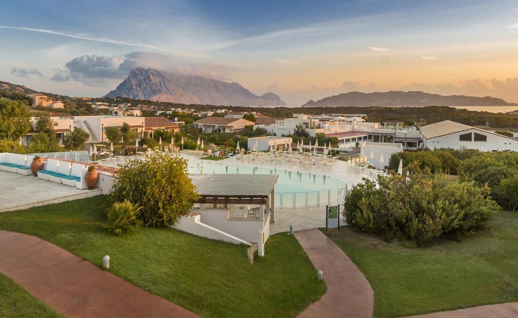 a resort with a pool with a mountain in the background at Grande Baia Resort & Spa in San Teodoro