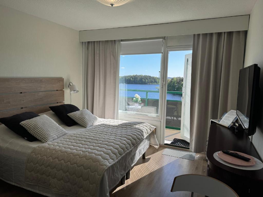 a bedroom with a bed and a view of the water at Hotelli Terme 616 in Kilvakkala