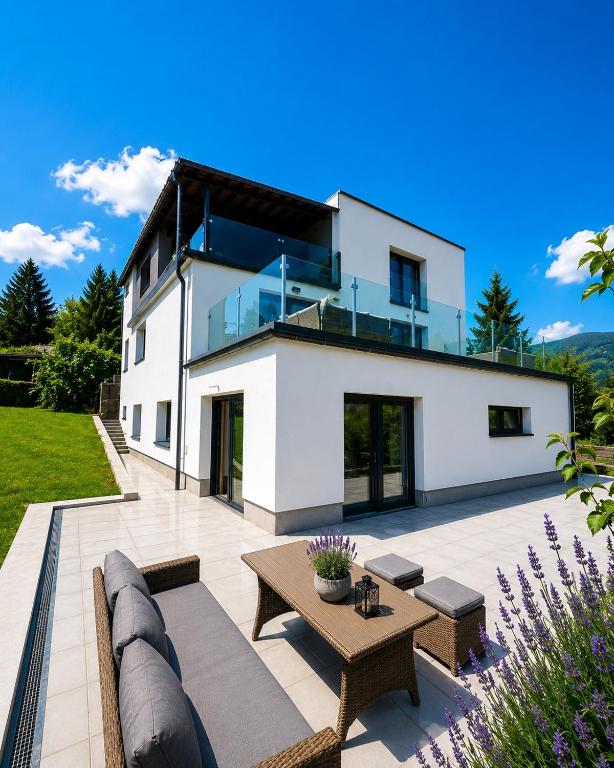 a large white house with a patio with a table at Levander 2 in Králiky