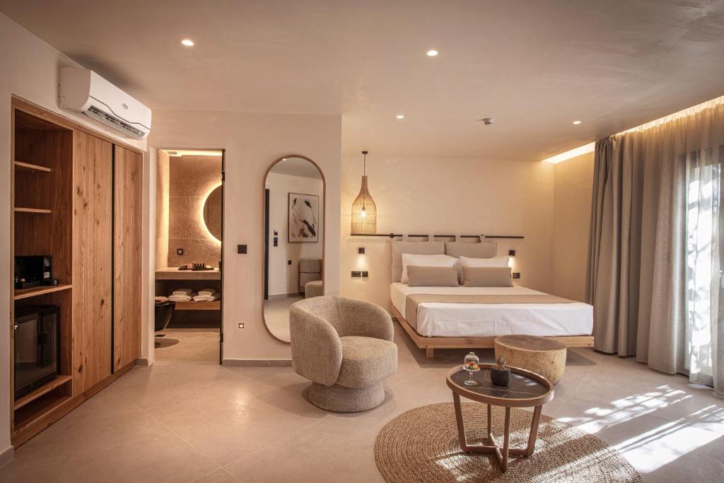 a large bedroom with a bed and a mirror at Indigo Suites Collection Adults Only in Hersonissos