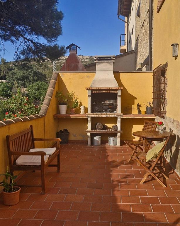 a patio with chairs and a fireplace on a building at LA CANTERICA in Fuentes de Rubielos