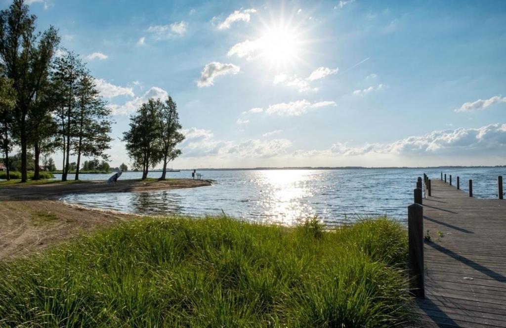 a boardwalk next to a body of water at Luxus Chalet Visarend 13 Strandkristall in Hulshorst
