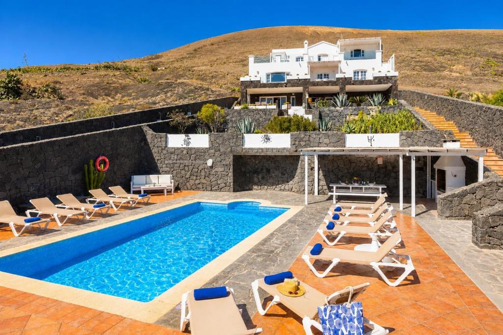 a villa with a swimming pool and a house at Villa Oasis de Asomada in La Asomada