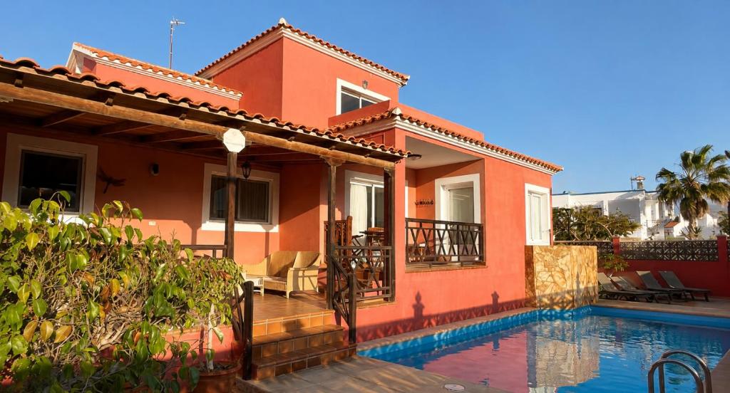 a house with a swimming pool in front of it at Brisa Vacacional - Adults Only in Corralejo