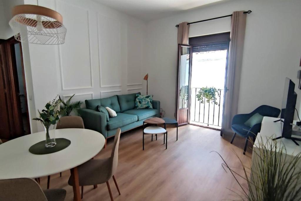 a living room with a blue couch and a table at Casa Yaye Puerta Palma in Écija