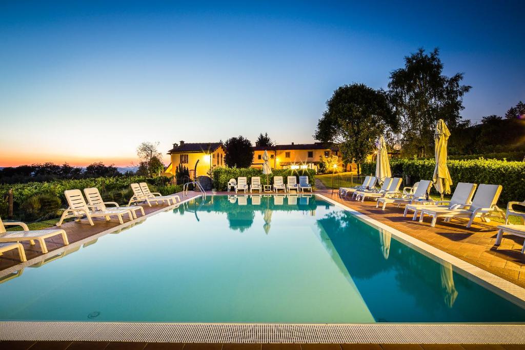 a swimming pool with lounge chairs and a resort at Agriturismo San Jacopo in Reggello