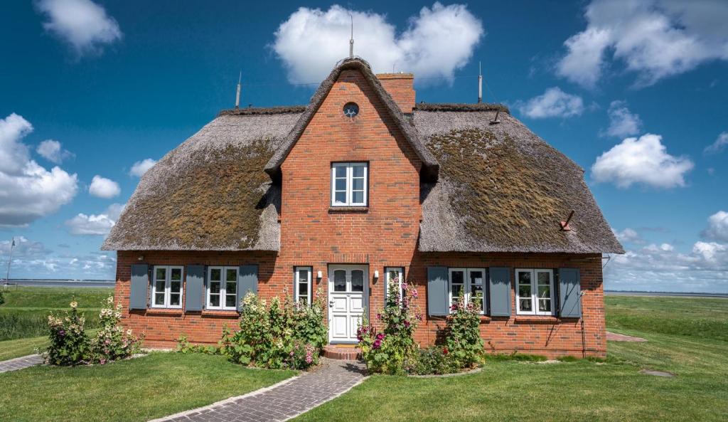 an old brick house with a thatched roof at Reethuus am Fething in Langeneß