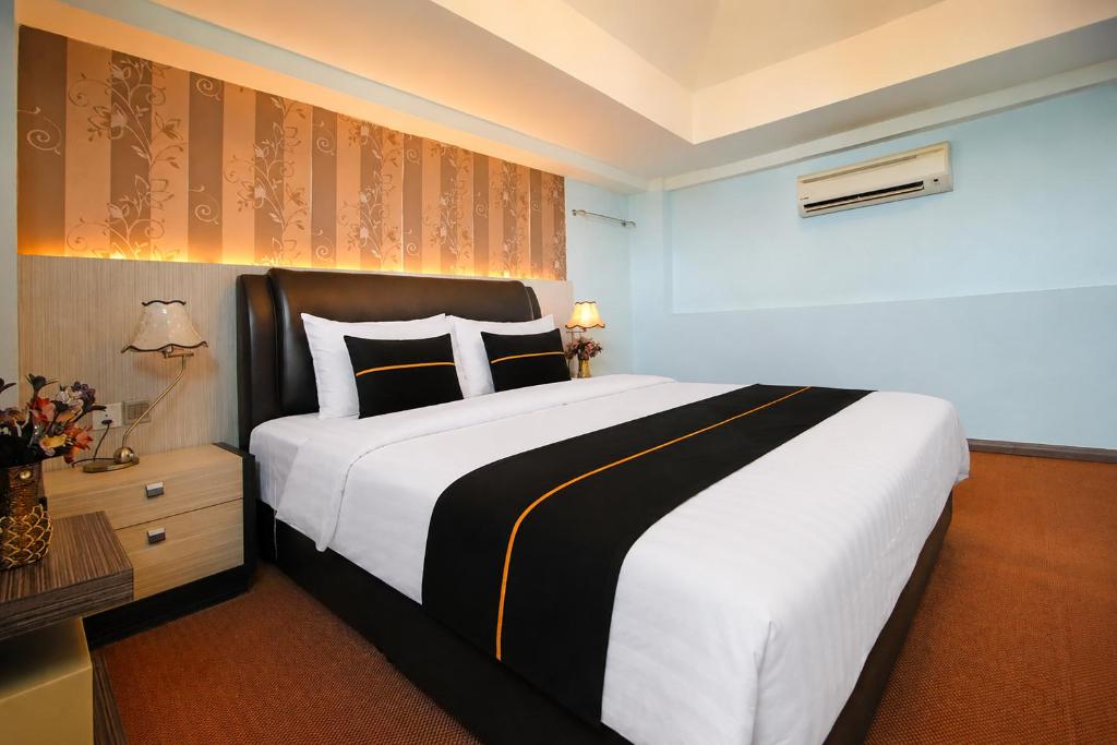 a bedroom with a large white bed and a desk at Collection O Near Tanjung Batu Formerly 4orty Inn in Bintulu