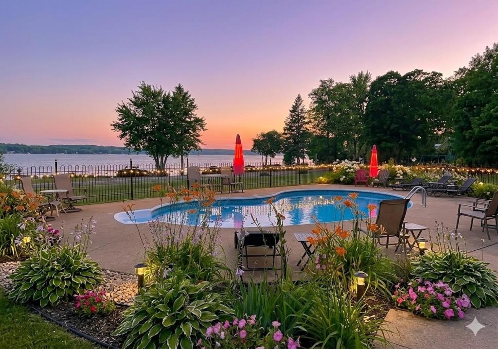 a swimming pool with chairs and flowers in a yard at Chalets Plage St-Jean 2 in Saint-Jean