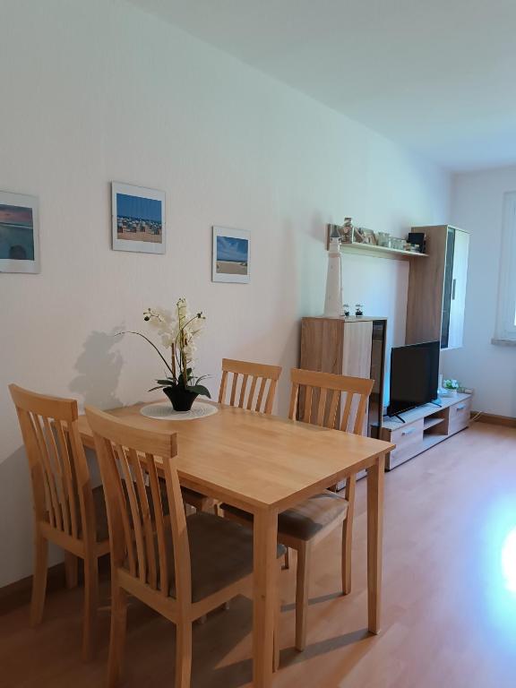 a wooden dining room table with chairs and a television at Ferienwohnung Karl 54 in Gelenau