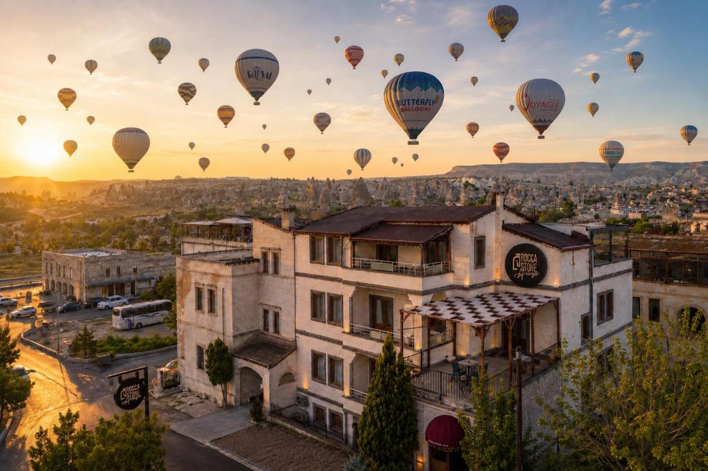 a group of hot air balloons flying over a city at Rocca Stone House in Göreme