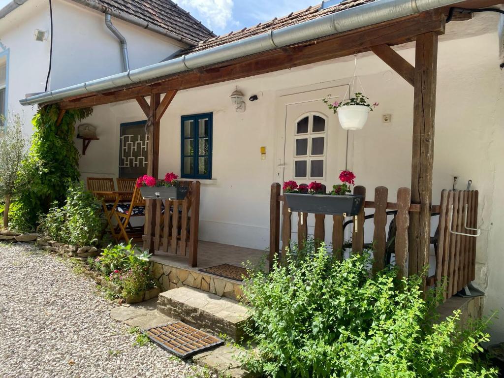 a white house with a wooden fence in front of it at Thermal Corner Guesthouse in Alsópáhok
