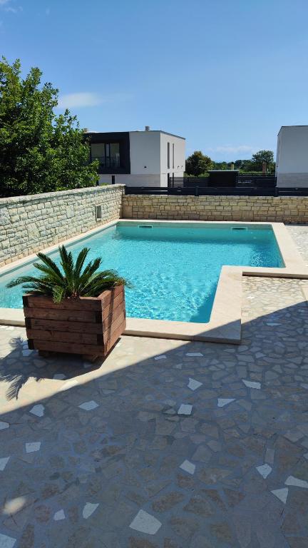 a large swimming pool with a brick wall at Apartment Istra Mare private pool & parking in Ližnjan