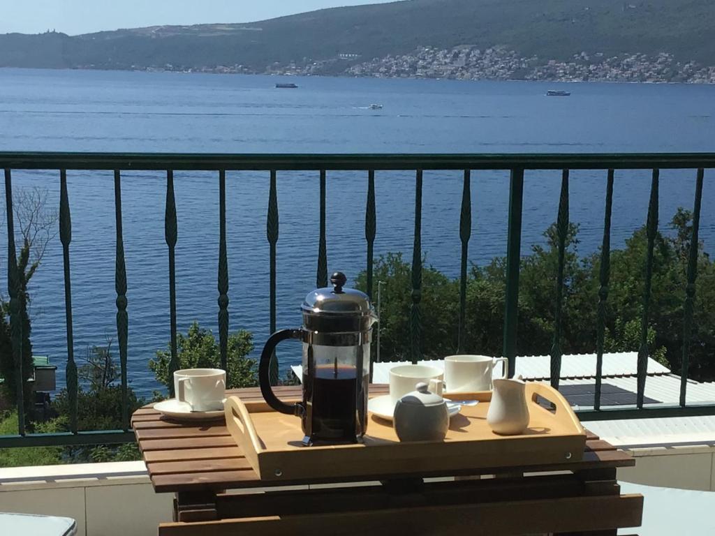 a tea kettle and cups on a table on a balcony at Adriadome Sky in Bijela