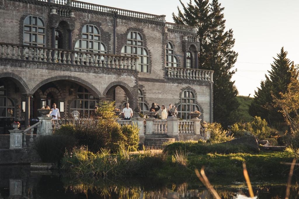 a group of people standing in front of a building at Vineam Castle - Manor Guesthouse in George