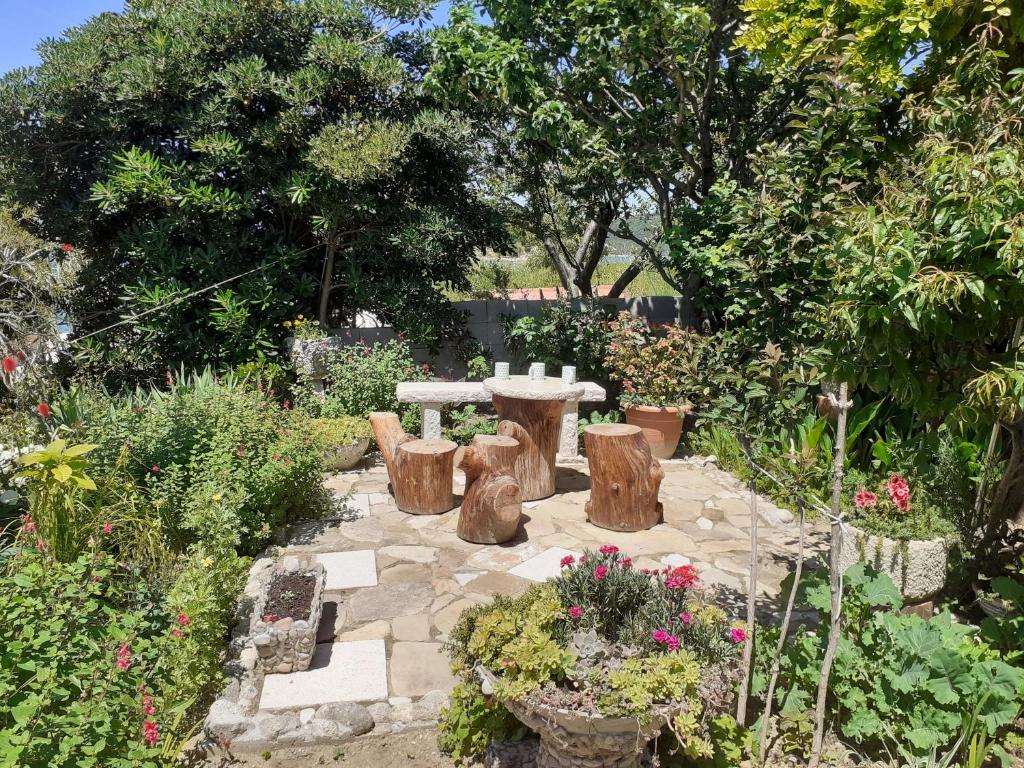 a garden with a table and some trees and flowers at Guest House Green Corner Supetarska Draga in Supetarska Draga