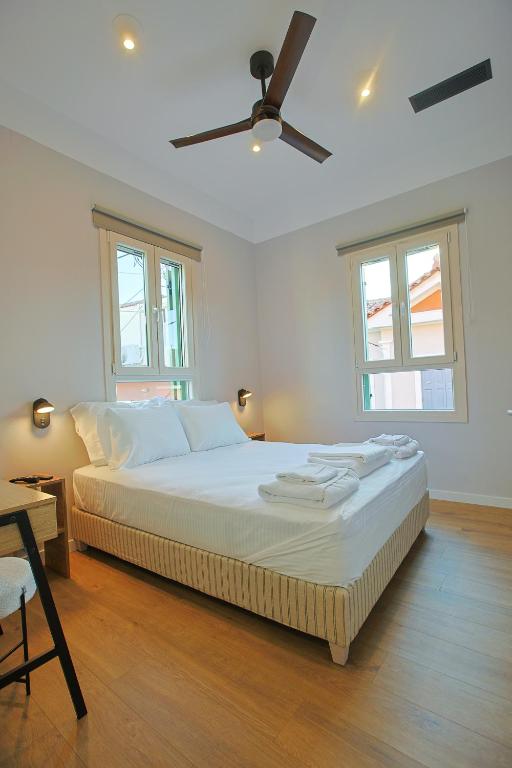 a bedroom with a bed and a ceiling fan at Makaros Nissos City in Mytilene