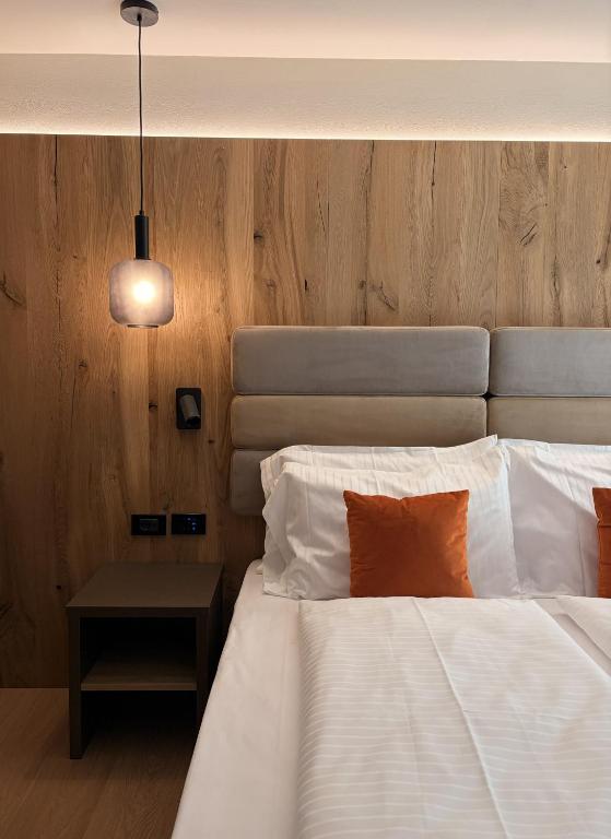a bedroom with a large white bed and a table at Alpen Relais in Fondo