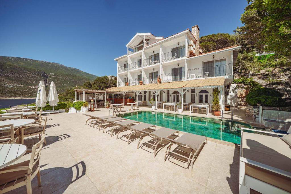 un hotel con piscina y sillas y un edificio en Arpia Hotel, en Kas