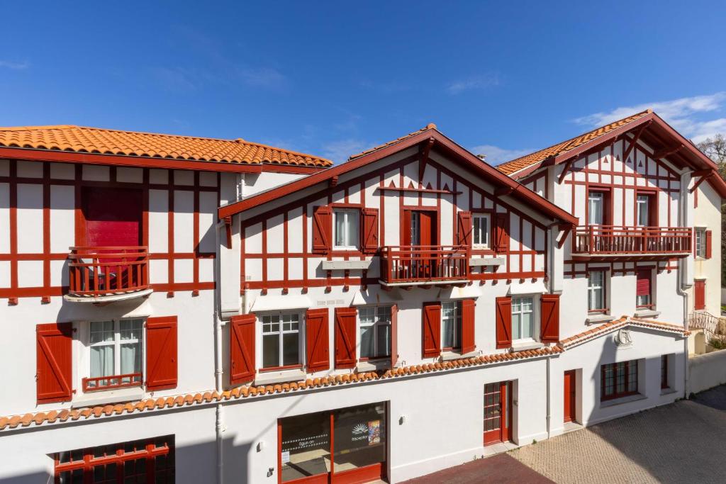 a row of buildings with red doors and balconies at Hôtel Kemaris in Biarritz