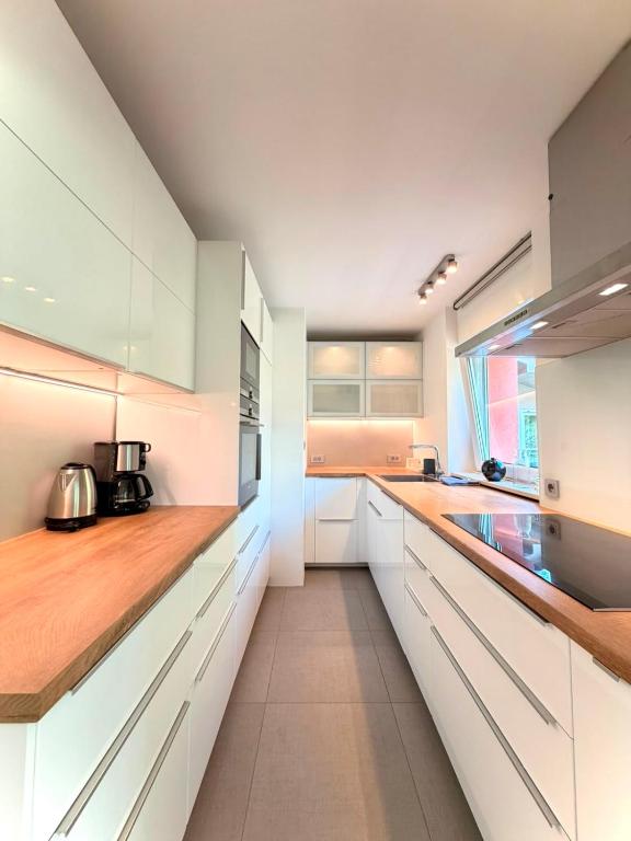 a kitchen with white cabinets and wooden counter tops at Central Townhouse with Parking in Ljubljana